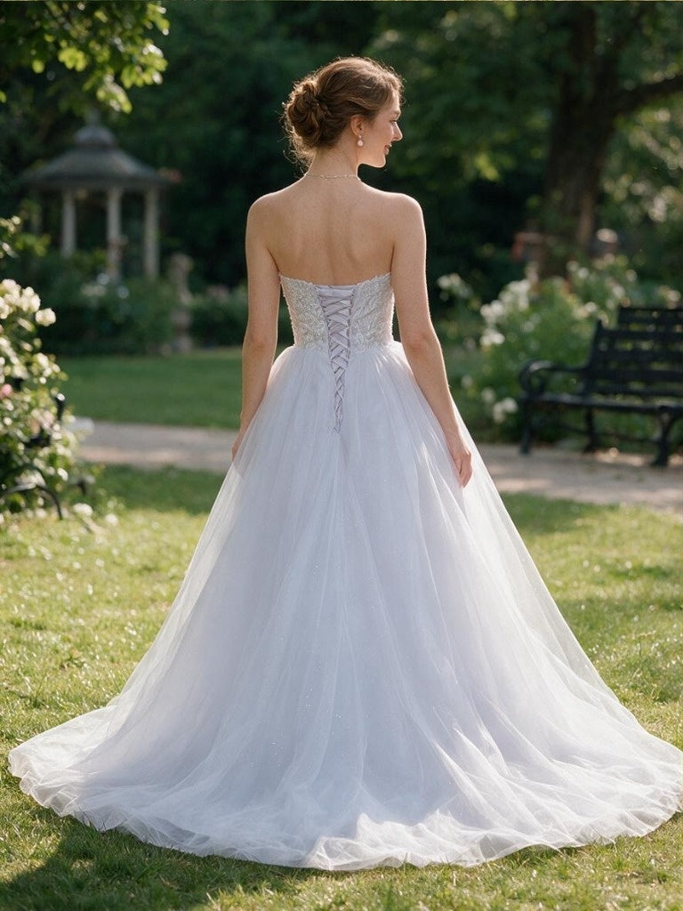 Lacey Bridal Ltd. Arabella strapless wedding gown with lace bodice, corset back, and full tulle skirt in a garden.
