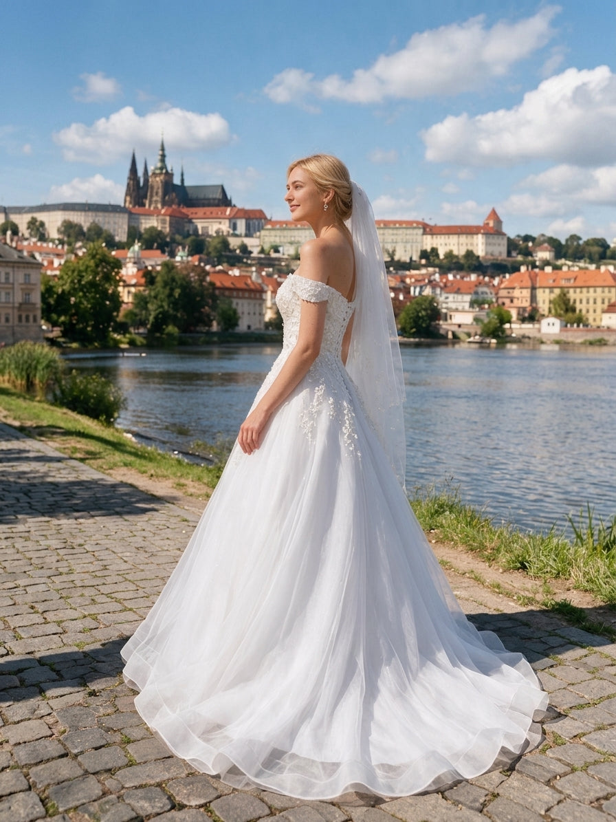 Lacey Bridal Ltd. Athena off-the-shoulder A-line wedding gown with lace appliqués and tulle skirt in Prague