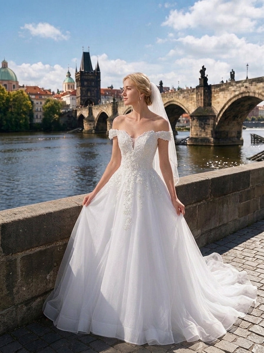 Lacey Bridal Ltd. Athena off-the-shoulder A-line wedding gown with lace appliqués and tulle skirt in Prague