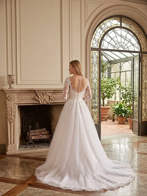 Lacey Bridal Ltd. Bianca A-line wedding gown with long illusion lace sleeves, button-back detail, and tulle skirt.