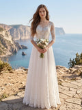 Lacey Bridal Ltd. Clarissa A-line wedding gown with illusion neckline, lace sleeves, and tulle skirt on a cliffside.