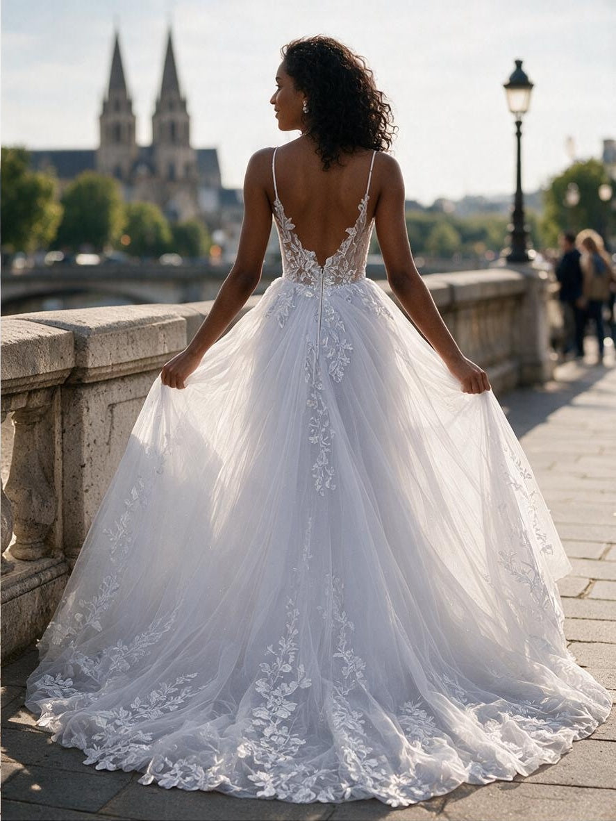 Lacey Bridal Ltd. Corinna A-line wedding gown with lace bodice, low V-back, and floral tulle train on a stone bridge.