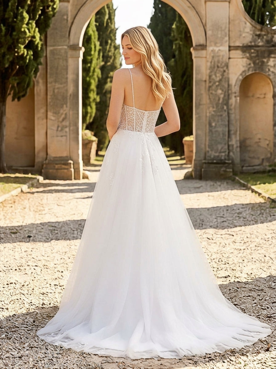 Lacey Bridal Ltd. Daphne A-line wedding gown with beaded bodice, spaghetti straps, and airy tulle skirt in a garden.