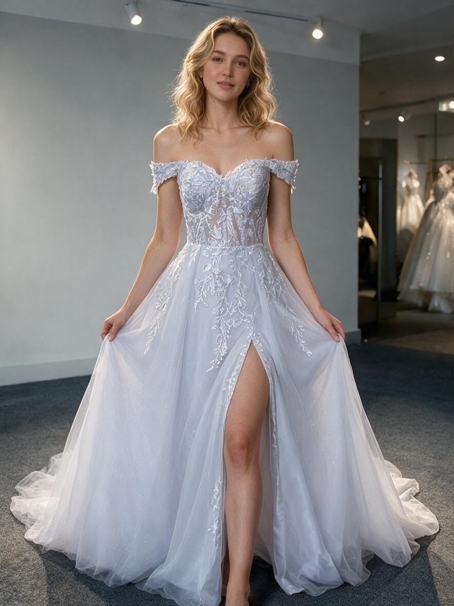 Lacey Bridal Ltd. Elysian A-line wedding dress with off-shoulder neckline, botanical lace, and tulle skirt with slit.