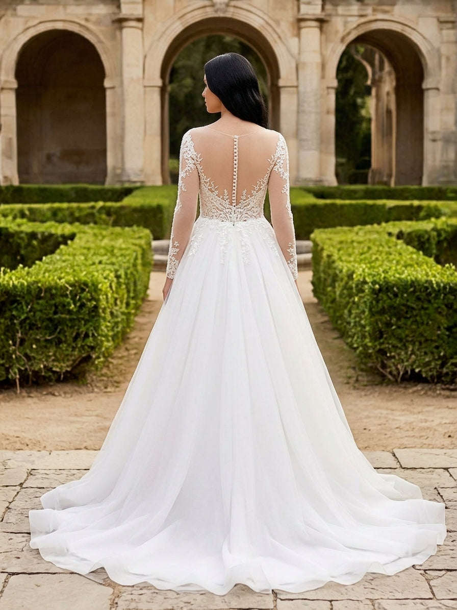 Lacey Bridal Ltd. EVA A-line wedding gown with illusion back, long lace sleeves, and flowing tulle skirt in a garden.