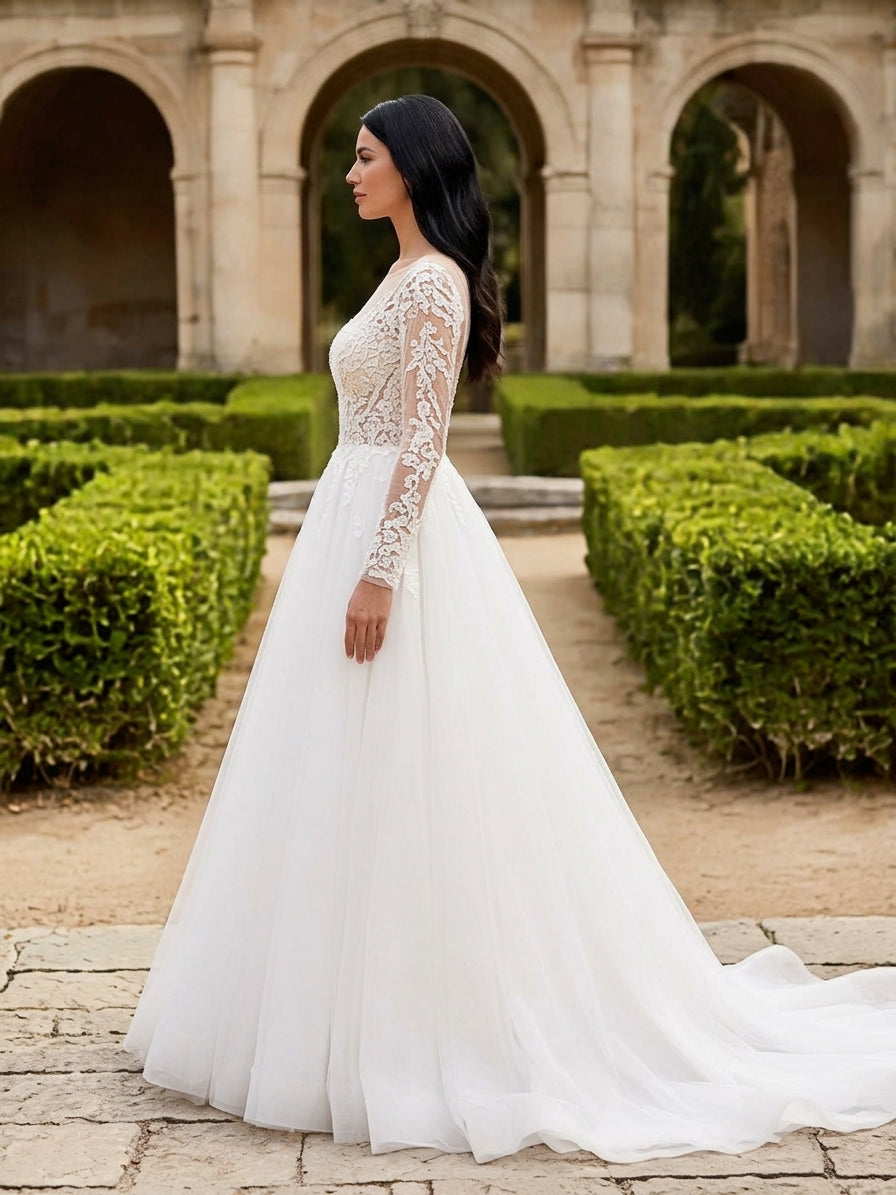 Lacey Bridal Ltd. EVA A-line wedding gown with long illusion lace sleeves and a full tulle skirt in a garden setting.