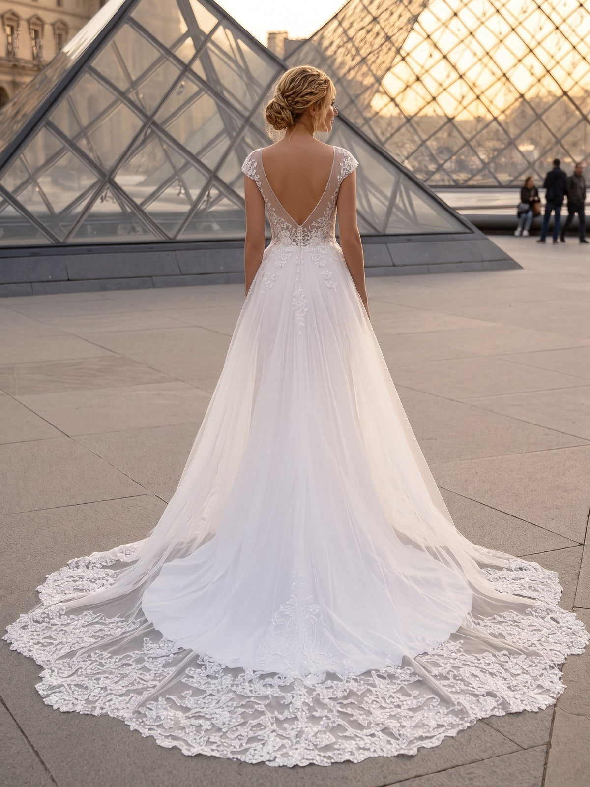 Lacey Bridal Ltd. Gemma wedding gown with detachable tulle train, illusion V-back, and intricate lace embroidery.