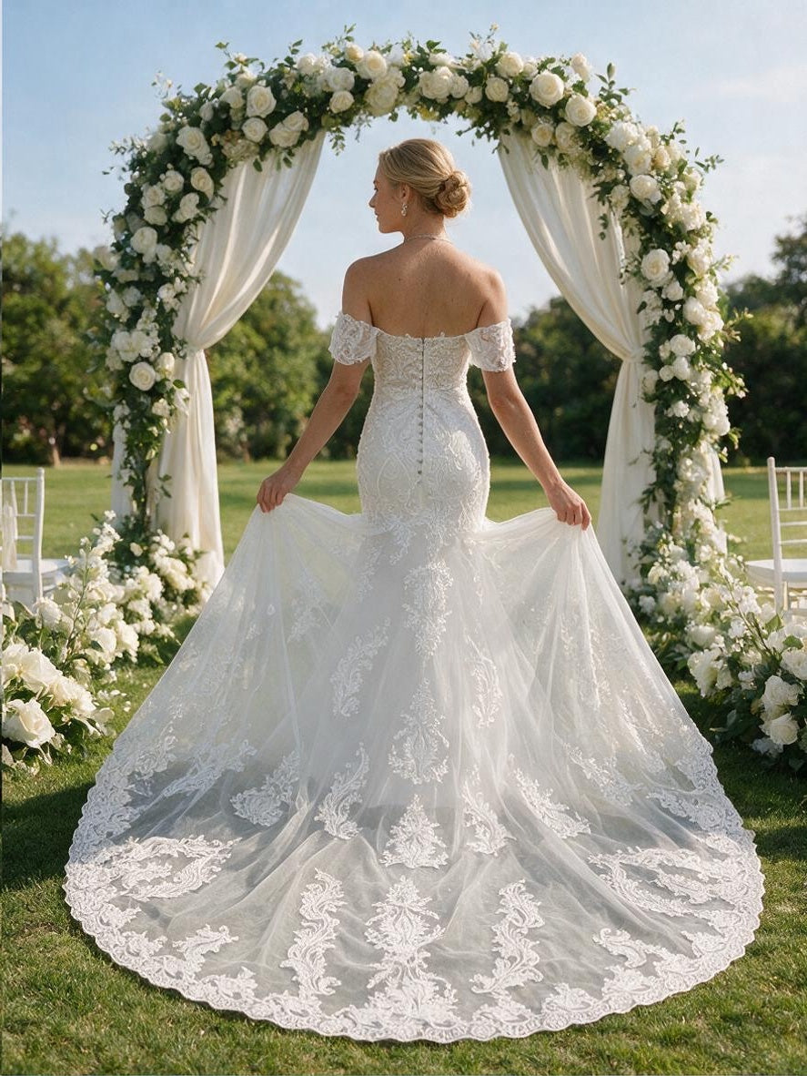 Lacey Bridal Ltd. GLORIA off-the-shoulder mermaid wedding gown with lace bodice, sheer back, and tulle train.