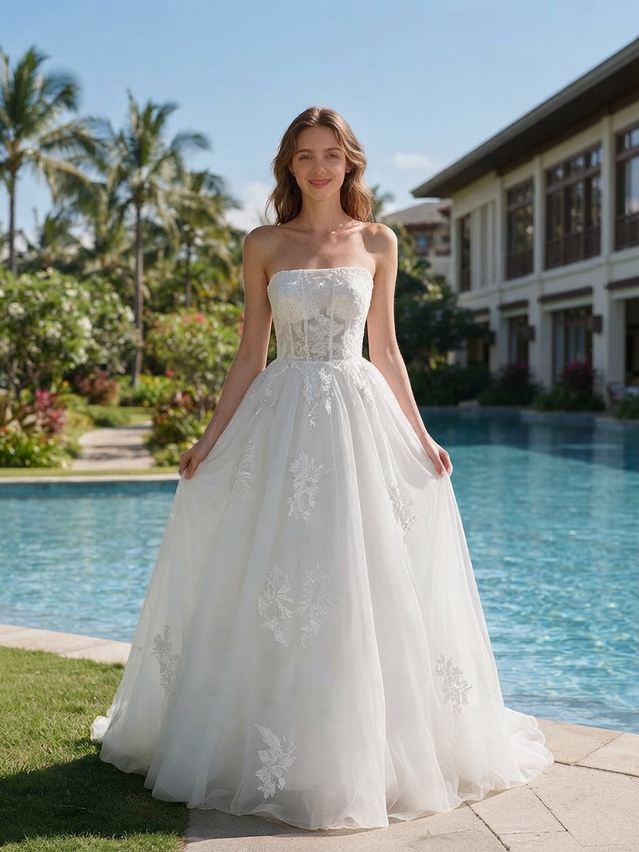 Lacey Bridal Ltd. Henrietta strapless A-line wedding gown with floral tulle skirt and corset bodice by a pool.