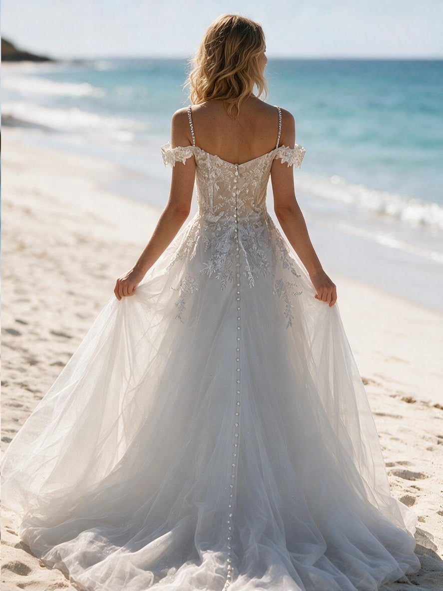 Lacey Bridal Ltd. Isabella A-line wedding gown with floral embroidery, illusion back, and tulle skirt on a beach.