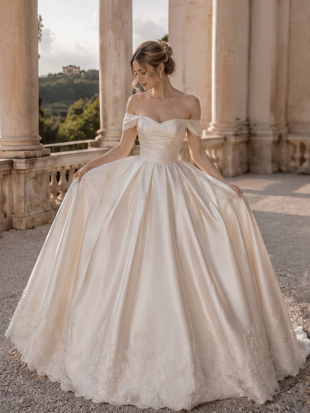 Lacey Bridal Ltd. JOVIENNE satin ball gown with off-the-shoulder neckline, ruched bodice, and beaded lace hem.