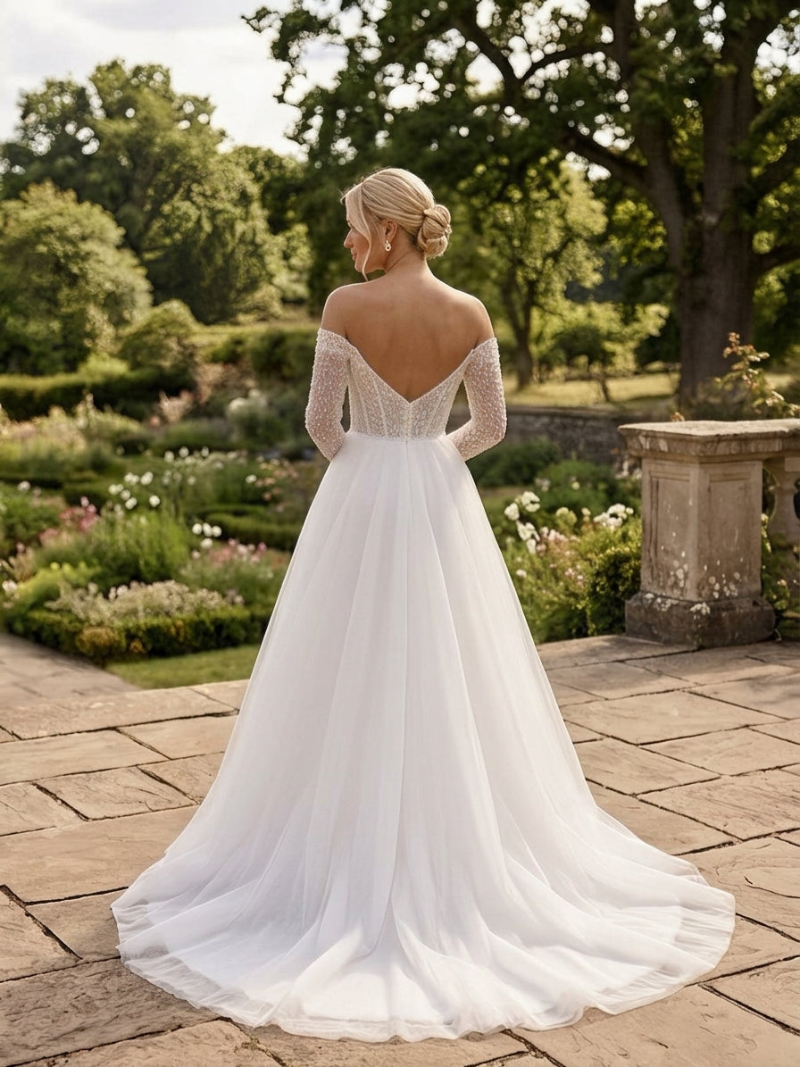 Lacey Bridal Ltd. Juliana A-line wedding gown with beaded illusion sleeves, low V-back, and flowing tulle skirt.