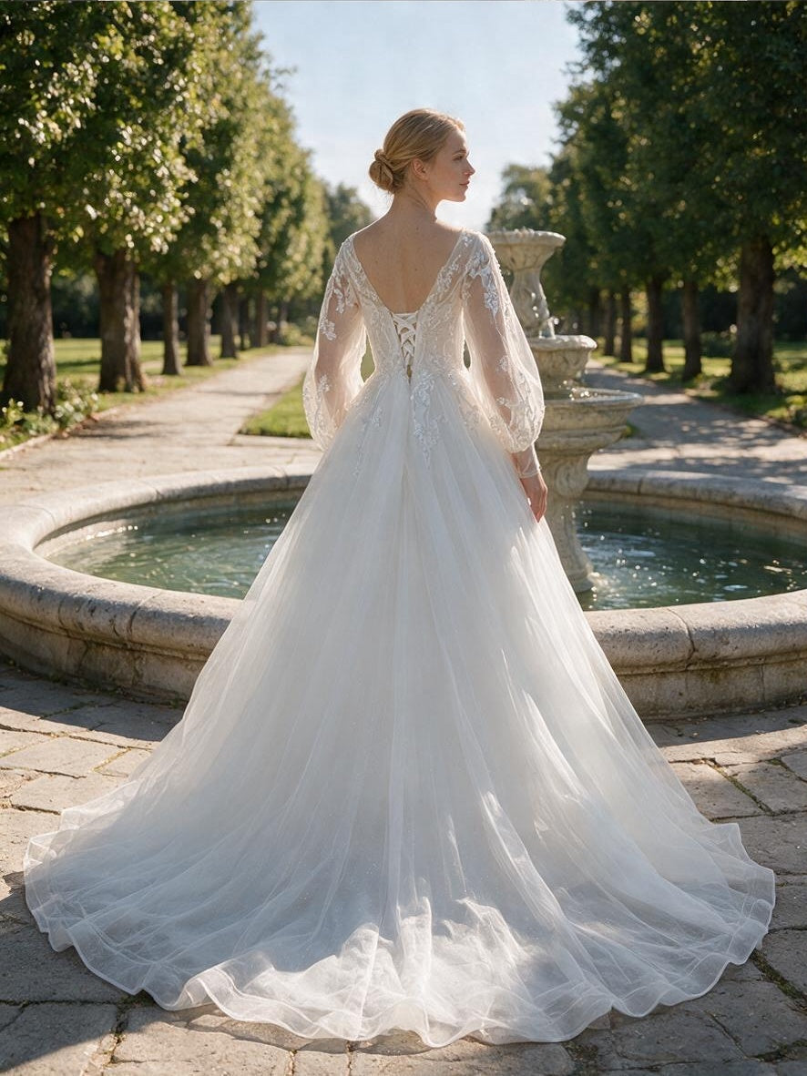 Lacey Bridal Ltd. Juliette A-line wedding gown with sheer bishop sleeves, lace-up corset back, and tulle train.
