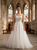 Lacey Bridal Ltd. KATHERINA A-line wedding gown with square neckline, sheer boned bodice, and floral tulle skirt.