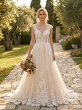 Lacey Bridal Ltd. LAVINIA blush-champagne A-line wedding gown with floral lace appliqué and plunging V-neckline.