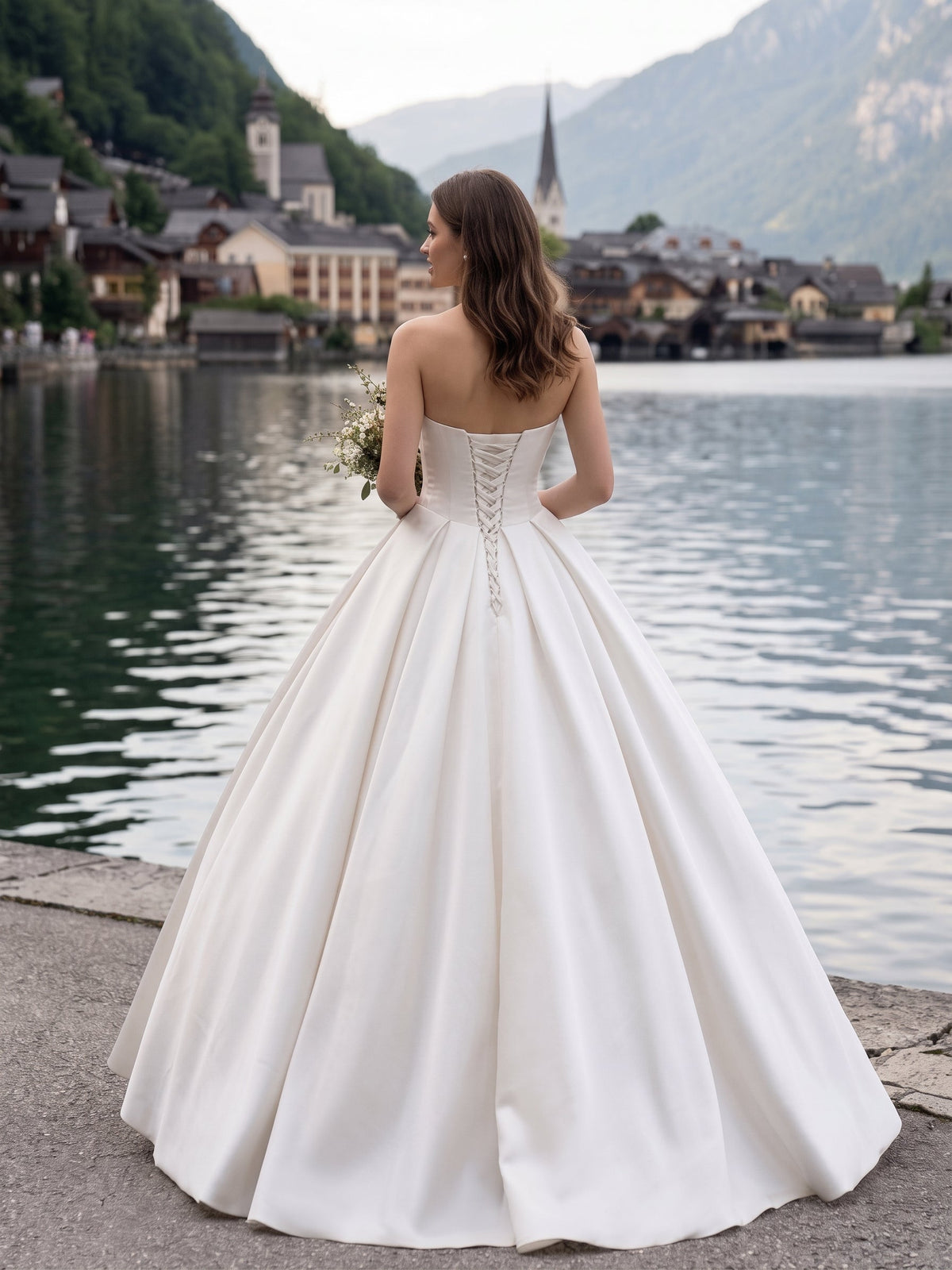 Lacey Bridal Ltd. Lucia satin ball gown with corset back and full skirt, worn by a bride at an Alpine lakeside.