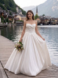 Lacey Bridal Ltd. LUCIA strapless satin ball gown with beaded lace appliqués on a wooden pier by an Alpine lake.