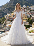 Lacey Bridal Ltd. MARINA off-the-shoulder ballgown with vine embroidery and tulle skirt on a coastal terrace.