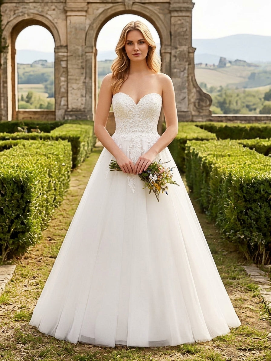 Lacey Bridal Ltd. Natalia strapless A-line wedding gown with floral lace bodice and flowing tulle skirt in a garden.