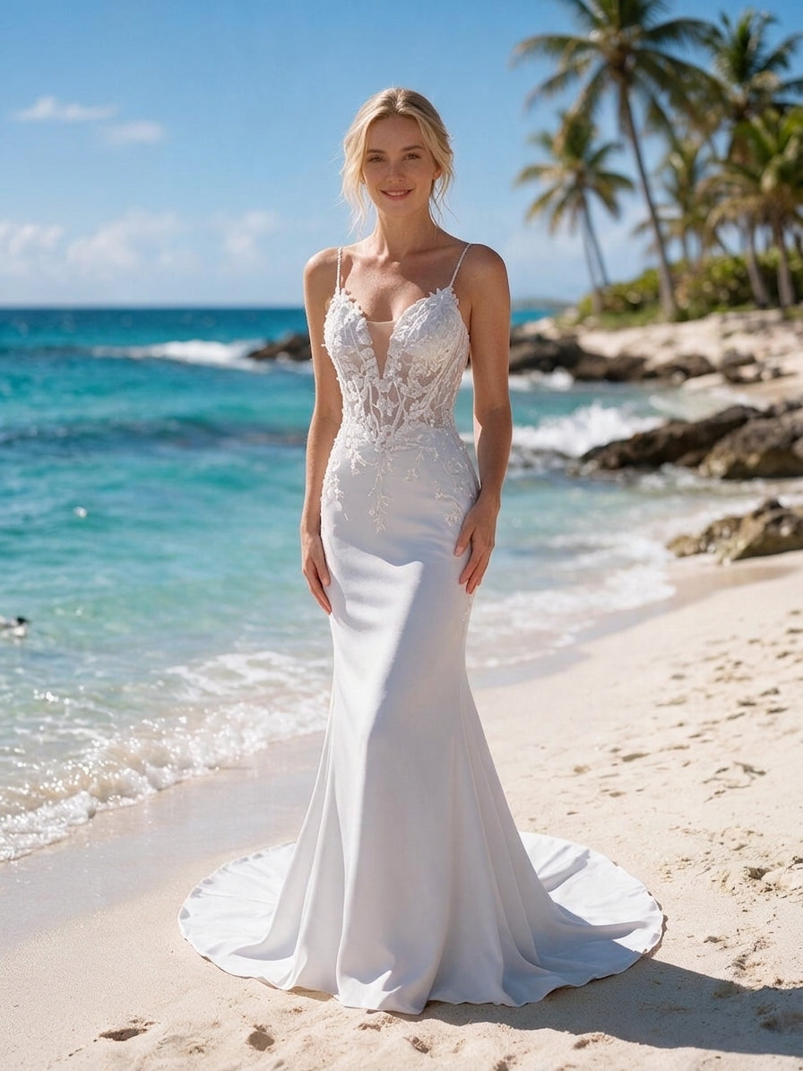 Lacey Bridal Ltd. Nicolette mermaid wedding gown with sheer lace bodice, plunging neckline, and sweep train on beach.
