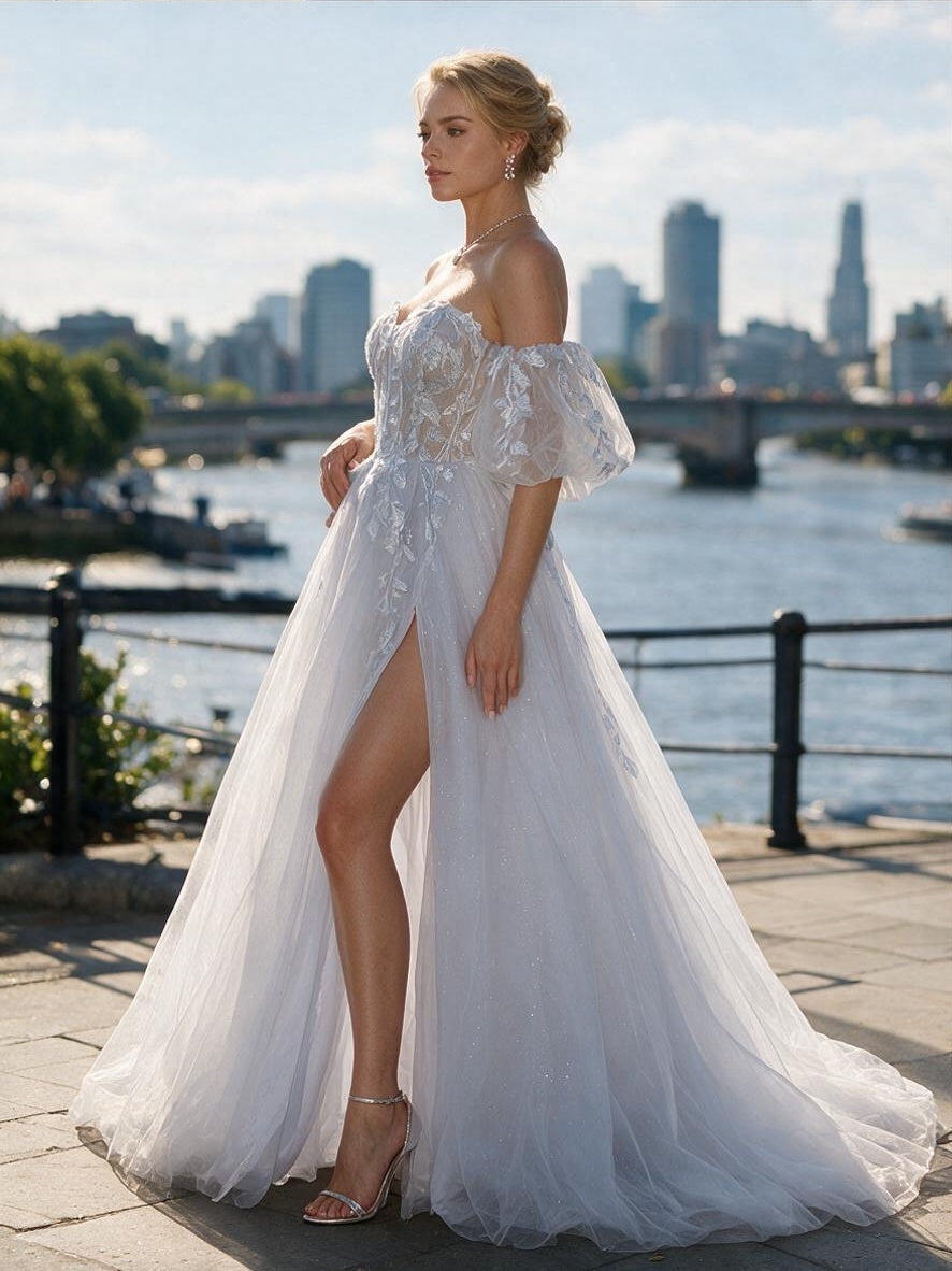 Lacey Bridal Ltd. Oriana icy A-line wedding gown with botanical embroidery, puff sleeves, and a high thigh slit.