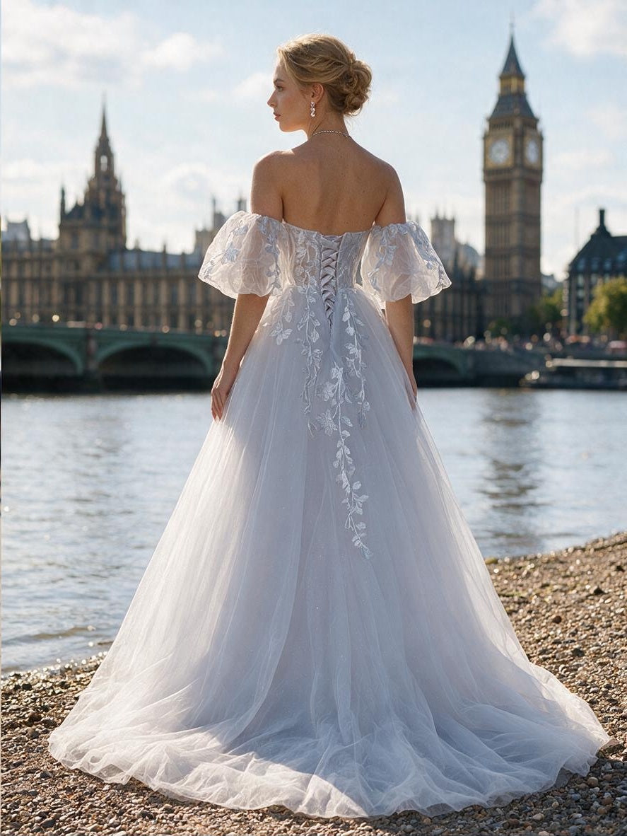 Lacey Bridal Ltd. ORIANA icy A-line wedding gown with off-the-shoulder puff sleeves and botanical lace embroidery.