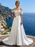 Lacey Bridal Ltd. Penelope A-line wedding dress with off-the-shoulder lace sleeves and crepe skirt on a cliffside.