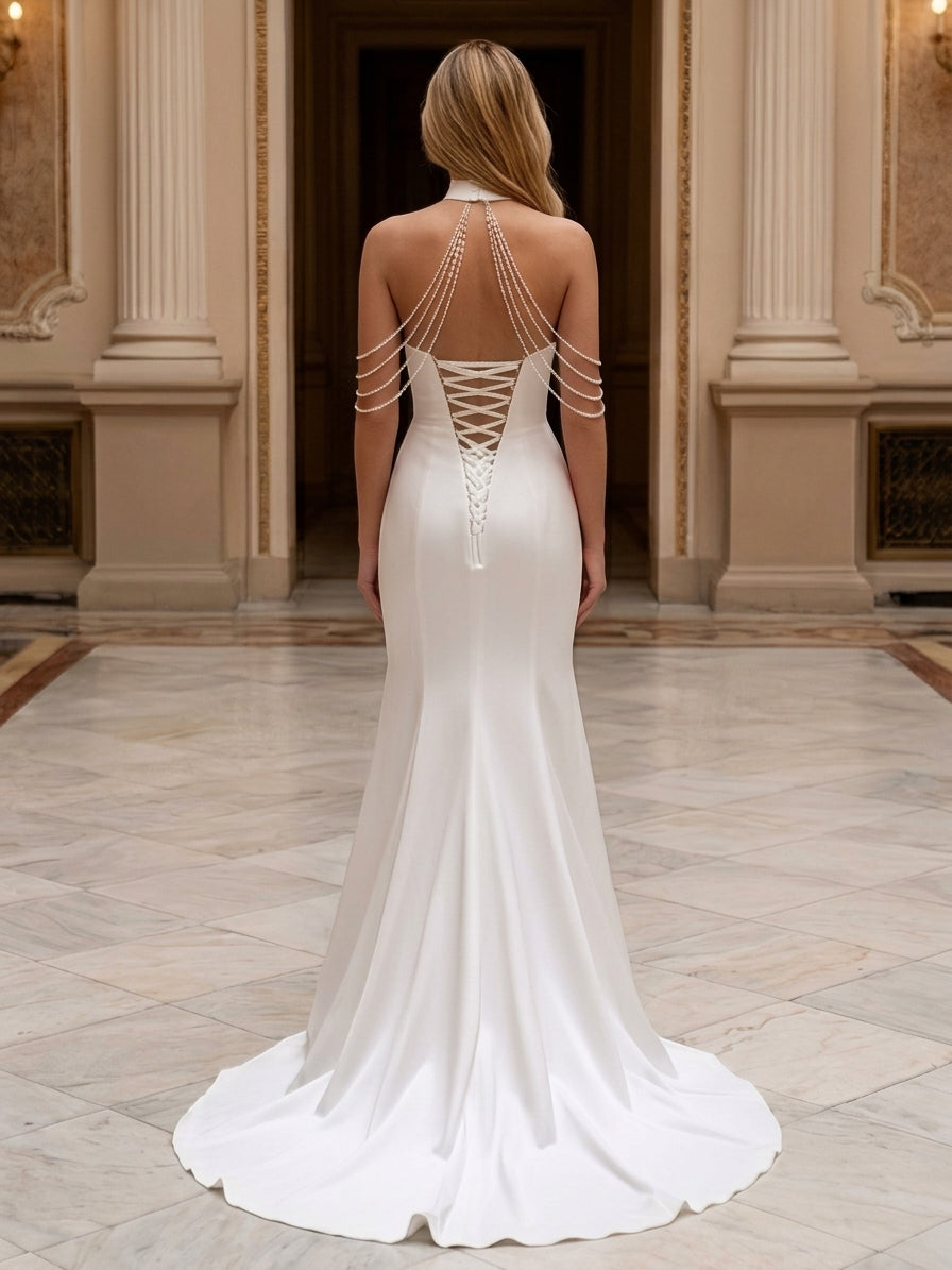 Lacey Bridal Ltd. PRIMULA white satin mermaid wedding gown with open back, corset lacing, and cascading pearl strands.