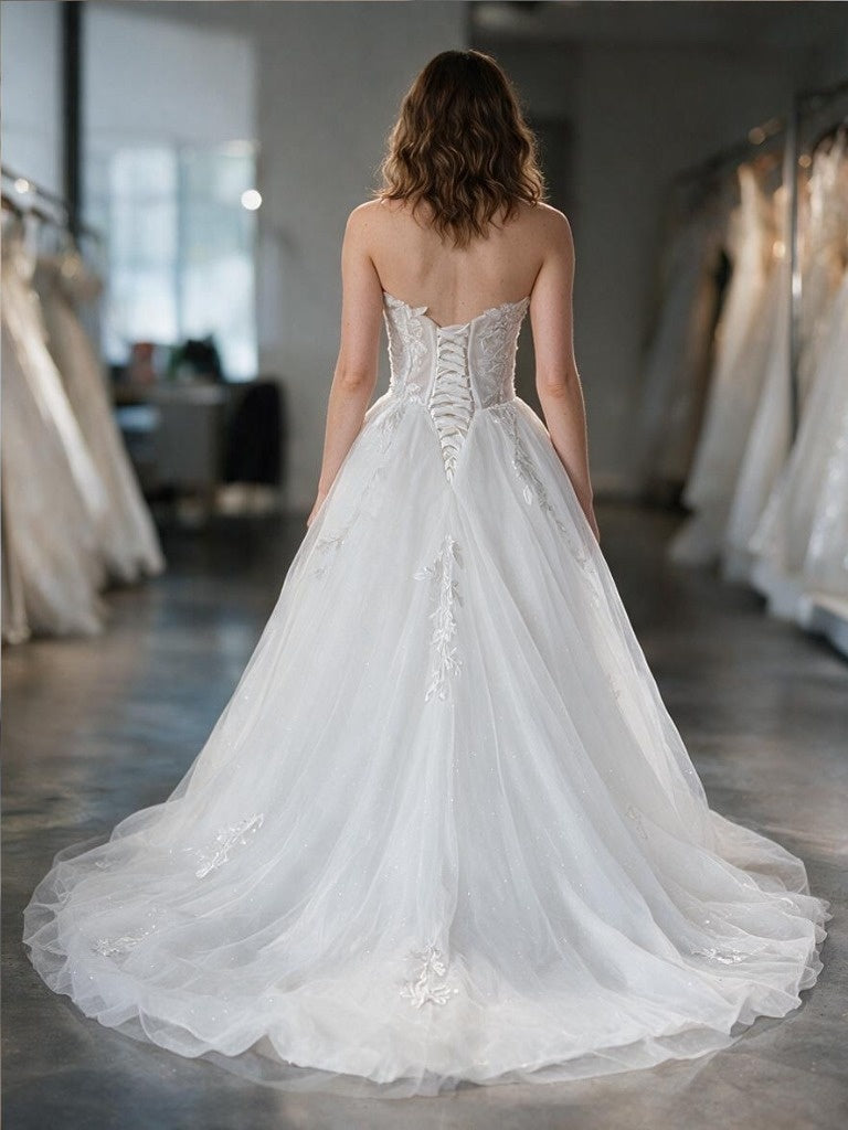 Lacey Bridal Ltd. Rosalind A-line wedding gown with lace-up corset back, glitter tulle skirt, and botanical lace.