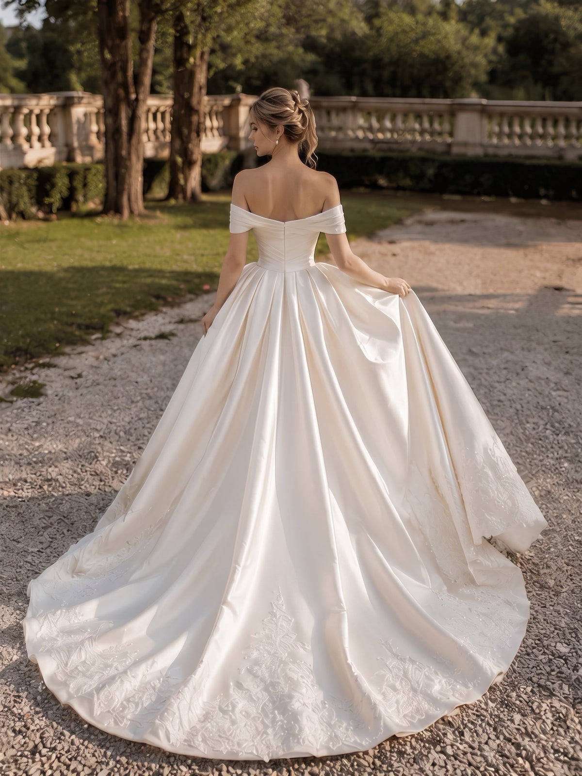 Lacey Bridal Ltd. JOVIENNE satin ball gown with off-the-shoulder neckline, ruched bodice, and beaded lace train.