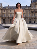 Lacey Bridal Ltd. DELIA strapless satin ball gown with pearl-beaded bodice and full skirt in a Parisian courtyard.