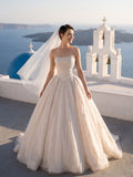 Lacey Bridal Ltd. Seraphine blush-champagne tulle ball gown with pearl-beaded corset bodice and full skirt