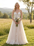 Lacey Bridal Ltd. Sibylla blush A-line wedding gown with floral lace bodice and tulle skirt in a meadow setting