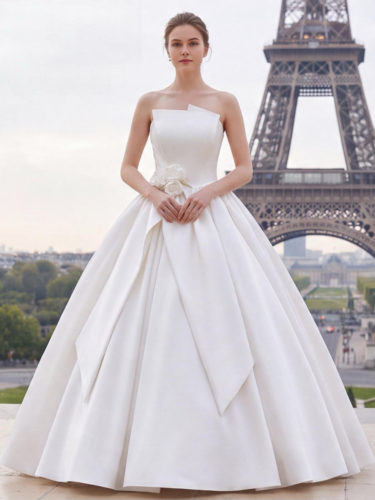 Lacey Bridal Ltd. strapless white satin ballgown with architectural folded neckline and floral waist accent in Paris.