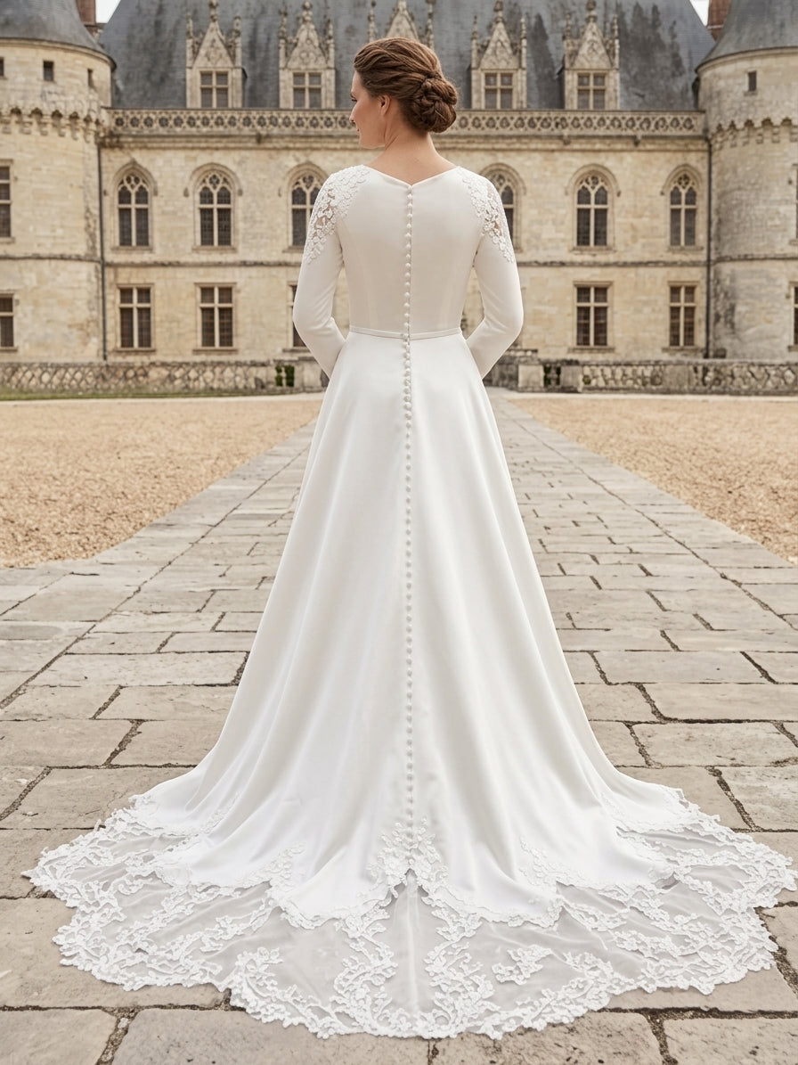 Lacey Bridal Ltd. Tatiana long-sleeve crepe A-line wedding dress with lace train and button-back detail.