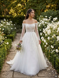 Lacey Bridal Ltd. TERESA A-line wedding gown with off-the-shoulder neckline, long illusion sleeves, and tulle skirt.
