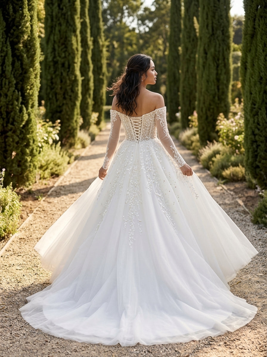 Lacey Bridal Ltd. Teresa A-line wedding gown with off-the-shoulder neckline, long illusion sleeves, and tulle skirt.