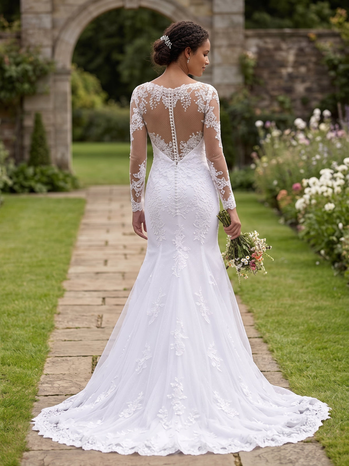 Lacey Bridal Ltd. THESPIA mermaid wedding gown with long illusion lace sleeves and button-back detail in a garden.