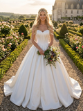 Lacey Bridal Ltd. VALENTIANA white satin ballgown with a strapless sweetheart bodice in a formal garden setting.