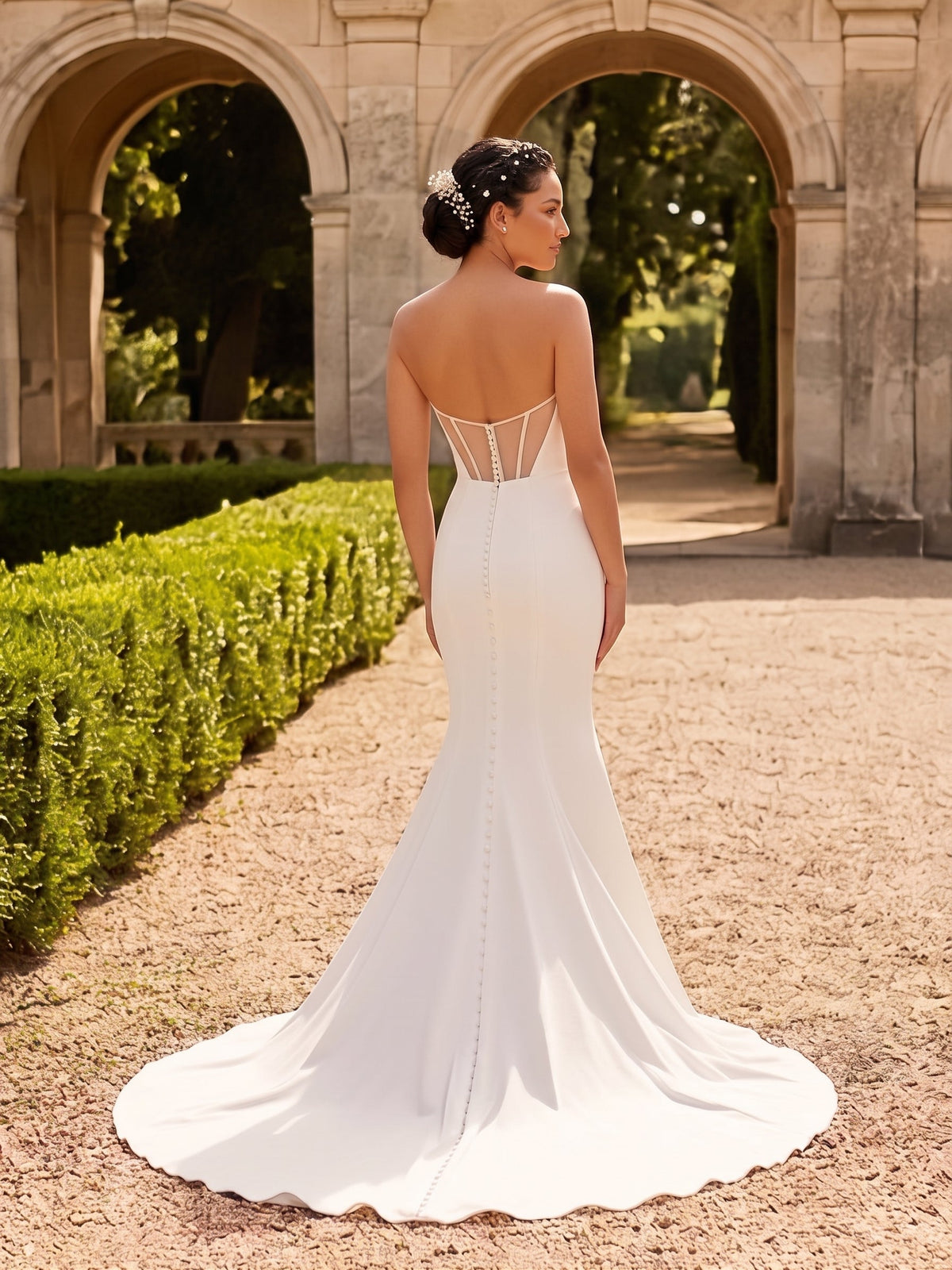 Back view of Lacey Bridal Ltd. Valeria mermaid wedding gown in white crepe with illusion panels and button details.