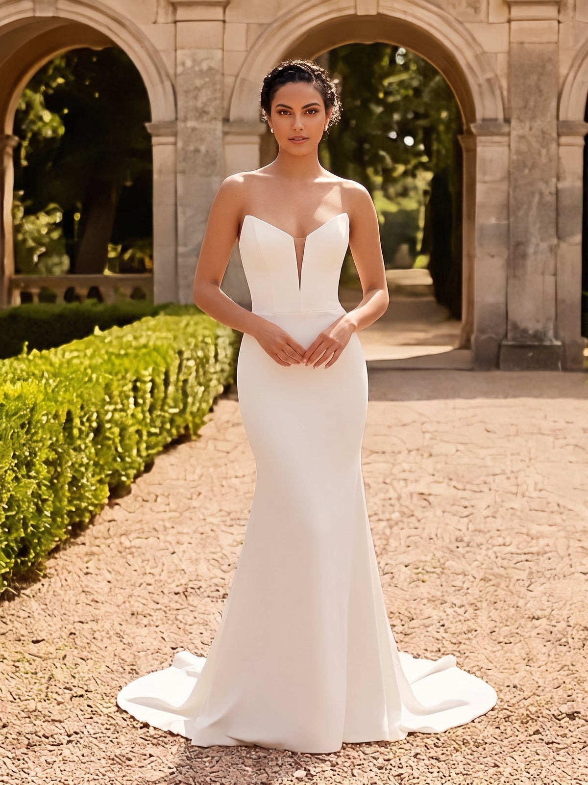 Lacey Bridal Ltd. Valeria mermaid wedding gown in white crepe with a strapless plunging neckline and corset bodice.