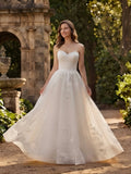 Lacey Bridal Ltd. Veronica strapless A-line wedding gown with floral lace appliqué and flowing tulle skirt in a garden