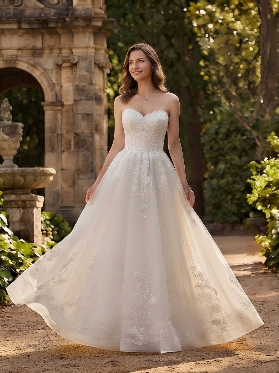 Lacey Bridal Ltd. Veronica strapless A-line wedding gown with floral lace appliqué and flowing tulle skirt in a garden