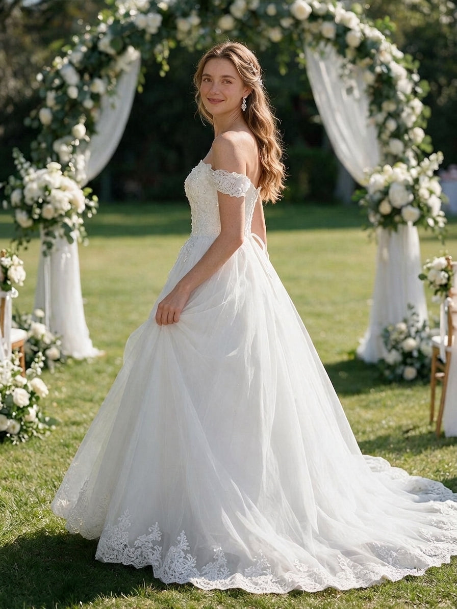 Lacey Bridal Ltd. Violetta A-line wedding gown with off-the-shoulder lace sleeves and tulle skirt in a garden setting