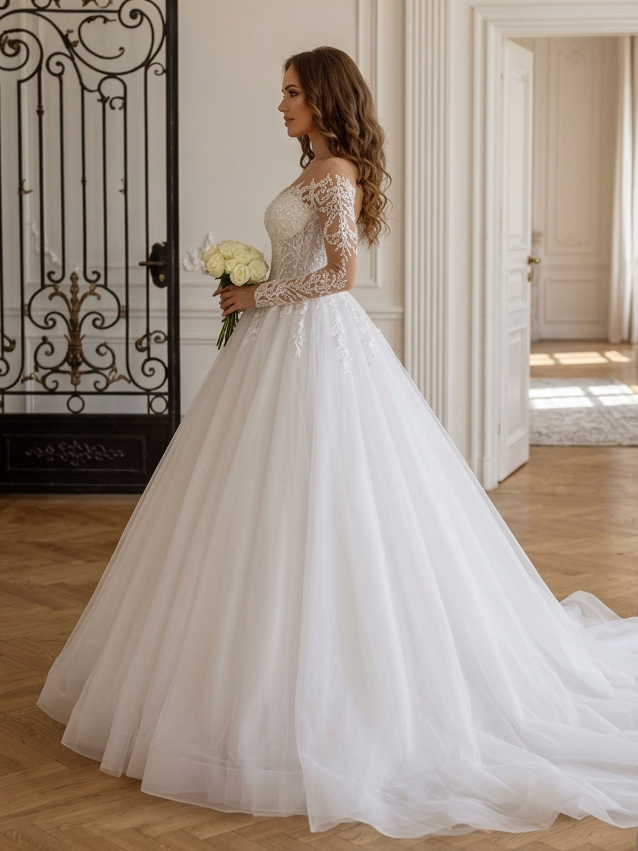 Lacey Bridal Ltd. Zelina ball gown with illusion sleeves, lace appliqué, and a full tulle skirt in a ballroom setting.